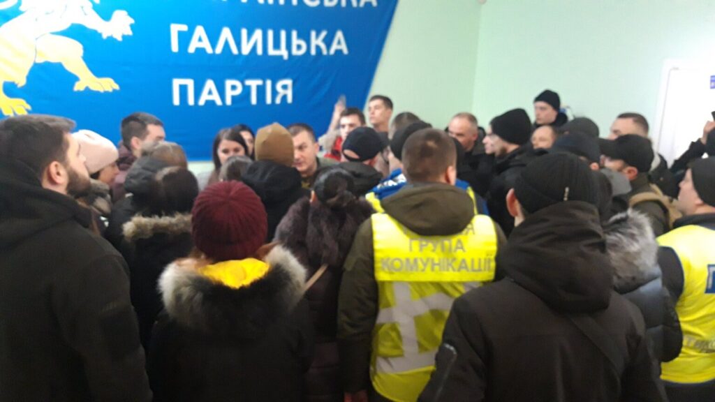 У четвер, 13 лютого, близько півсотні вуличних активістів увірвалися в львівський офіс Української Галицької Партії на вул. Костюшка, 18. Учасники штурму, називаючи себе ветеранами, намагались погрожувати членам партії та відвідувачам громадського офісу.

DrogMedia Нацкорпус увірвався в офіс Української Галицької Партії у Львові

Голова політради Української Галицької Партії  Ірина Моряк у коментарі ZAXID.NET розповіла, що пов’язує штурм партійного офісу з інцидентом, що відбувся 8 лютого під час політичної акції проти виділення землі під будівництво готельно-розважального комплексу на вул. Дорошенка, 2. За словами очільниці Української Галицької Партії , тоді під час акції протесту на представницю їхньої партії Ірину Бек скоїв напад невідомий чоловік, який штовхав активістку і вибив з її рук мобільний телефон.

«В наш офіс увірвалися люди, які назвалися ветеранами. У натовпі були люди, пов’язані з депутатом ЛМР Григорієм Козловським. Ми вважаємо це помстою одіозного депутата за акцію на вул. Дорошенка. У такий спосіб нас хочуть змусити мовчати про факти розкрадання землі та майна громади. Однак ми в Галичині не боїмося бандитів і спроб залякування, а також підтримуємо всіх справжніх ветеранів», – розповіла Ірина Моряк.

Вона також додала, що учасники штурму перебували в офісі партії близько 40 хвилин, після чого покинули приміщення. З приводу інциденту керівництво Української Галицької Партії звернулося в поліцію. Правоохоронці прибули на місце конфлікту.

DrogMedia Нацкорпус увірвався в офіс Української Галицької Партії у Львові

На фото і відео з місця події видно, що в провокації серед інших брали участь особи з символікою «Національного корпусу», також у натовпі помітно учасників штурмів львівської ратуші, акцій проти будівництва заводу гарячого цинкування у Винниках та пікетів біля будинку мера Львова Андрія Садового.

Після завершення штурму офісу Української Галицької Партії на сторінці «Національного Корпусу. Львівщина» у Facebook з’явився допис про те, що організація дає Української Галицької Партії два дні на офіційні вибачення, а в протилежному випадку члени «Національного Корпусу» вдаватимуться до рішучих дій.

12 лютого на сайті «Національного корпусу» з’явилась публікація про те, що організація підтримує військового, на якого Української Галицької Партії нібито здійснила наклеп.

Сайт «Національного корпусу» зацитував допис на сторінці у Facebook львів’янина Ігоря «Сармата» Хая, який звинуватив членів Української Галицької Партії у тому, що вони спровокували на конфлікт його батька Володимира Хая, а потім поширили відео інциденту у соцмережах. Чоловік також опублікував фотографію батька із зони АТО.

Конфлікт між чоловіком та представниками Української Галицької Партії відбувся на місці майбутнього будівництва торгово-готельного комплексу на вул. Дорошенка, 2, впритул до «Гранд готелю», що належить Григорію Козловському. У жовтні 2019 року виконком ЛМР дозволив там будівництво фірмі, що належить доньці депутата ЛМР Григорія Козловського Софії Максимець та ще одній львів’янці Лесі Данчевській. Депутати УГП у Львівській міськраді неодноразово заявляли про порушення при відчужені з комунальної власності земельної ділянки під цей готель, активісти цієї партії організовували кілька акції протесту на місці майбутнього будівництва.

Нагадаємо, Українська Галицька Партія системно виступає проти незаконного розкрадання землі у Львові.

У 2018 році нам важко, але таки вдалось відстояти Цитадель.

Наприкінці 2018 році нарешті отримали перемогу у парку Знесіння, якийвідстоювали  роками 

Більше року фракція Української Галицької Партії у Львівській міській раді  неодноразово намагалась відстояти землю у центрі міста.

Зокрема, на сесії ЛМР  25 квітня  2019 року депутати фракції УГП застерігали про цю земельну схему і просили інших депутатів не підтримувати питання щодо ОСББ – відео зі сесії з 07:51:15 год

Та більшість депутатів вирішили віддати комунальну землю, що коштує мільйони – безкоштовно. Після цього наші депутати намагались відстояти ділянку на Дорошенка на громадських слуханнях щодо цього питання. Тут виступає, наприклад, голова фракції УГП у ЛМР Тарас Чолій: https://www.facebook.com/watch/?v=2213340498969934

На рішення виконкому  не вплинули навіть публікації зовнішніх медіа про земельну схему і ГРАНДіозний план Козловського і таки погодили містобудівні документи. Та УГП не припинила відстоювати клаптик землі у Львові.  Юристи партії уже звернулись до:

Державного бюро розслідувань
Генеральної прокуратури
Прокуратури Львівської обл.
Головного управління нацполіції Львівської обл.
Спеціалізованої антикорупційної прокуратури
Джерело