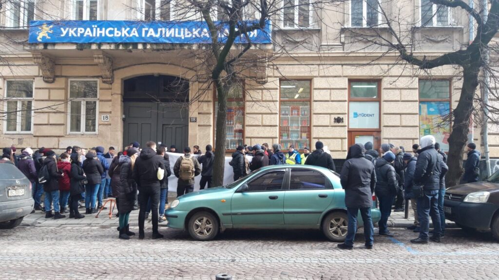 У четвер, 13 лютого, близько півсотні вуличних активістів увірвалися в львівський офіс Української Галицької Партії на вул. Костюшка, 18. Учасники штурму, називаючи себе ветеранами, намагались погрожувати членам партії та відвідувачам громадського офісу.

DrogMedia Нацкорпус увірвався в офіс Української Галицької Партії у Львові

Голова політради Української Галицької Партії  Ірина Моряк у коментарі ZAXID.NET розповіла, що пов’язує штурм партійного офісу з інцидентом, що відбувся 8 лютого під час політичної акції проти виділення землі під будівництво готельно-розважального комплексу на вул. Дорошенка, 2. За словами очільниці Української Галицької Партії , тоді під час акції протесту на представницю їхньої партії Ірину Бек скоїв напад невідомий чоловік, який штовхав активістку і вибив з її рук мобільний телефон.

«В наш офіс увірвалися люди, які назвалися ветеранами. У натовпі були люди, пов’язані з депутатом ЛМР Григорієм Козловським. Ми вважаємо це помстою одіозного депутата за акцію на вул. Дорошенка. У такий спосіб нас хочуть змусити мовчати про факти розкрадання землі та майна громади. Однак ми в Галичині не боїмося бандитів і спроб залякування, а також підтримуємо всіх справжніх ветеранів», – розповіла Ірина Моряк.

Вона також додала, що учасники штурму перебували в офісі партії близько 40 хвилин, після чого покинули приміщення. З приводу інциденту керівництво Української Галицької Партії звернулося в поліцію. Правоохоронці прибули на місце конфлікту.

DrogMedia Нацкорпус увірвався в офіс Української Галицької Партії у Львові

На фото і відео з місця події видно, що в провокації серед інших брали участь особи з символікою «Національного корпусу», також у натовпі помітно учасників штурмів львівської ратуші, акцій проти будівництва заводу гарячого цинкування у Винниках та пікетів біля будинку мера Львова Андрія Садового.

Після завершення штурму офісу Української Галицької Партії на сторінці «Національного Корпусу. Львівщина» у Facebook з’явився допис про те, що організація дає Української Галицької Партії два дні на офіційні вибачення, а в протилежному випадку члени «Національного Корпусу» вдаватимуться до рішучих дій.

12 лютого на сайті «Національного корпусу» з’явилась публікація про те, що організація підтримує військового, на якого Української Галицької Партії нібито здійснила наклеп.

Сайт «Національного корпусу» зацитував допис на сторінці у Facebook львів’янина Ігоря «Сармата» Хая, який звинуватив членів Української Галицької Партії у тому, що вони спровокували на конфлікт його батька Володимира Хая, а потім поширили відео інциденту у соцмережах. Чоловік також опублікував фотографію батька із зони АТО.

Конфлікт між чоловіком та представниками Української Галицької Партії відбувся на місці майбутнього будівництва торгово-готельного комплексу на вул. Дорошенка, 2, впритул до «Гранд готелю», що належить Григорію Козловському. У жовтні 2019 року виконком ЛМР дозволив там будівництво фірмі, що належить доньці депутата ЛМР Григорія Козловського Софії Максимець та ще одній львів’янці Лесі Данчевській. Депутати УГП у Львівській міськраді неодноразово заявляли про порушення при відчужені з комунальної власності земельної ділянки під цей готель, активісти цієї партії організовували кілька акції протесту на місці майбутнього будівництва.

Нагадаємо, Українська Галицька Партія системно виступає проти незаконного розкрадання землі у Львові.

У 2018 році нам важко, але таки вдалось відстояти Цитадель.

Наприкінці 2018 році нарешті отримали перемогу у парку Знесіння, якийвідстоювали  роками 

Більше року фракція Української Галицької Партії у Львівській міській раді  неодноразово намагалась відстояти землю у центрі міста.

Зокрема, на сесії ЛМР  25 квітня  2019 року депутати фракції УГП застерігали про цю земельну схему і просили інших депутатів не підтримувати питання щодо ОСББ – відео зі сесії з 07:51:15 год

Та більшість депутатів вирішили віддати комунальну землю, що коштує мільйони – безкоштовно. Після цього наші депутати намагались відстояти ділянку на Дорошенка на громадських слуханнях щодо цього питання. Тут виступає, наприклад, голова фракції УГП у ЛМР Тарас Чолій: https://www.facebook.com/watch/?v=2213340498969934

На рішення виконкому  не вплинули навіть публікації зовнішніх медіа про земельну схему і ГРАНДіозний план Козловського і таки погодили містобудівні документи. Та УГП не припинила відстоювати клаптик землі у Львові.  Юристи партії уже звернулись до:

Державного бюро розслідувань
Генеральної прокуратури
Прокуратури Львівської обл.
Головного управління нацполіції Львівської обл.
Спеціалізованої антикорупційної прокуратури
Джерело
